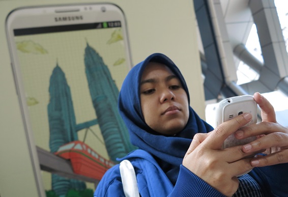 写真2　クアラルンプールでスマートフォンを利用するイスラーム教徒女性