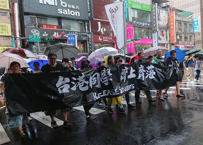 写真：写真2「台湾と香港の学生は、ともに登りともに落ちる」 と書かれた横断幕を手に香港支援デモを行う台湾の学生たち。