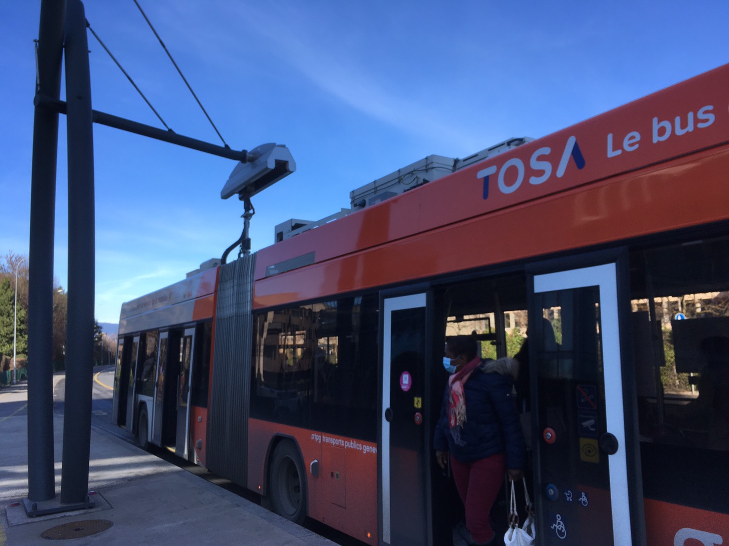写真1　高速で充電を行う電動バス。バスから充電部分が伸びてきてバス停にある充電施設と連結する。