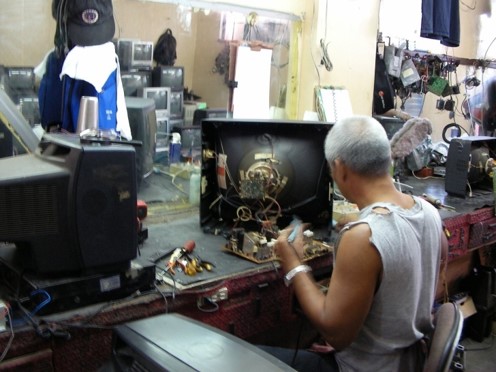 Photo 2. A Worker replacing used parts with new ones at the Secondhand TV shop in the Philippines,photo by M. Kojima, 2007.