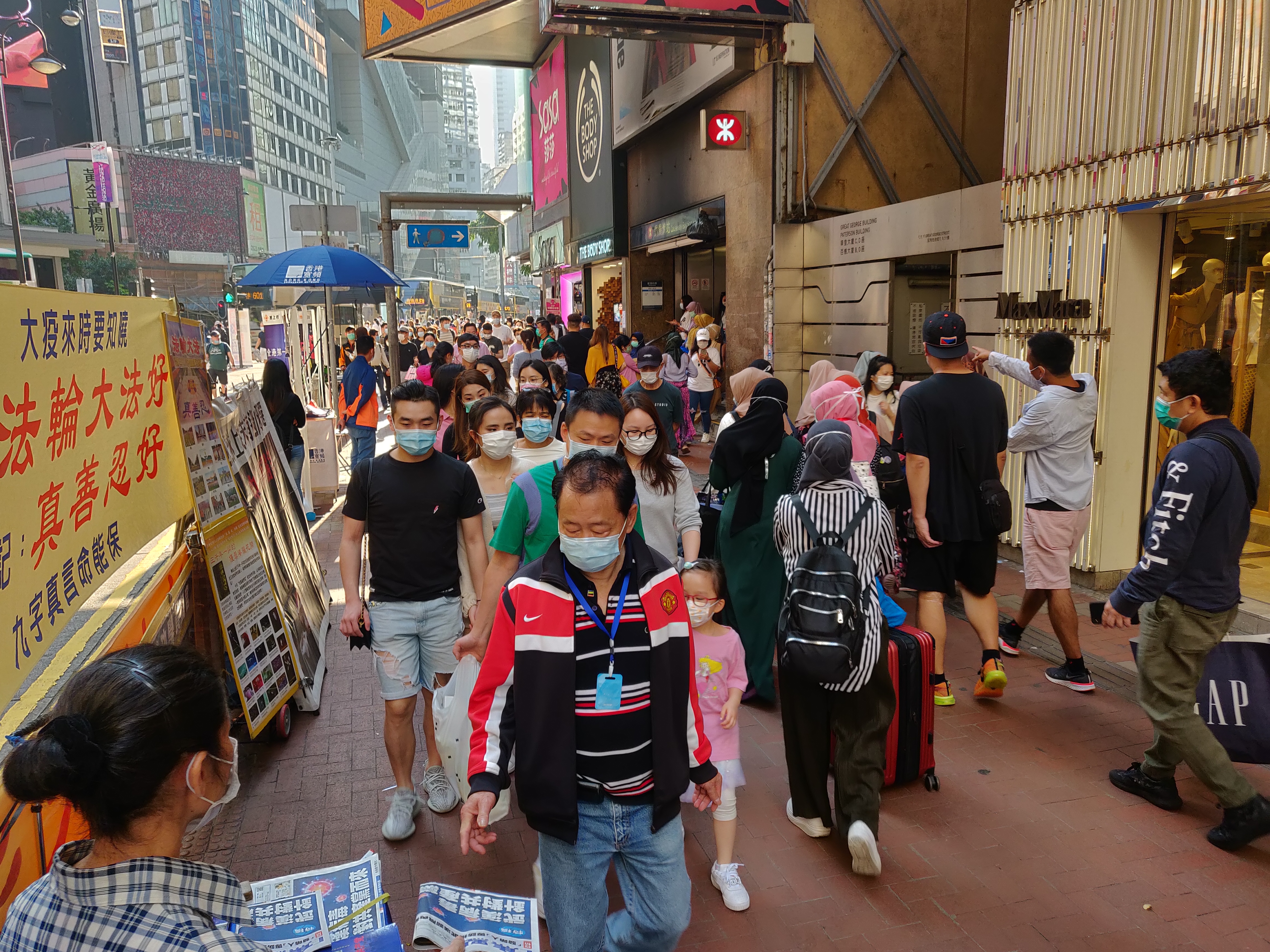 写真：マスクを着けて歩く香港の人々。
