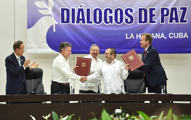 和平合意を締結し握手を交わすサントス大統領（中央左）とロンドニョFARC最高司令官（中央右）。署名式典には潘基文（パン・ギムン）国連事務総長も出席（左端）