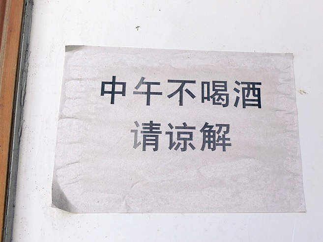 写真：村民委員会の壁に貼られた「昼食時は飲酒禁止」の張り紙