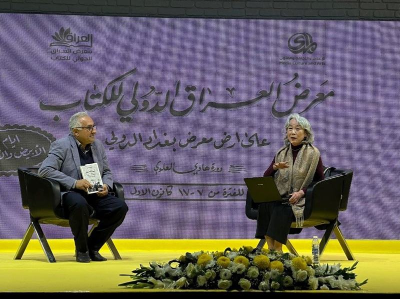 写真2　2022年、バグダードの国際ブックフェアの「著者は語る」コーナーに突然上げられ、アラビア語訳された拙著について、アラビア語でいきなりプレゼンした。左は訳者のMahmoud al-Qaysiバグダード大学教授