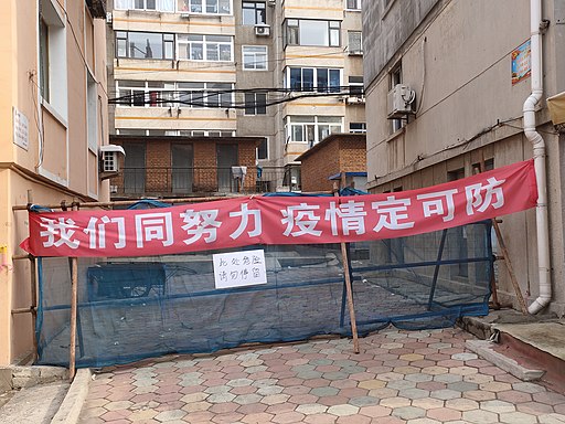 写真：路地の入口を封鎖するバリケードに掲げられた反COVID-19 のスローガン（中国遼寧省大連市旅順口区、2020年2月）。