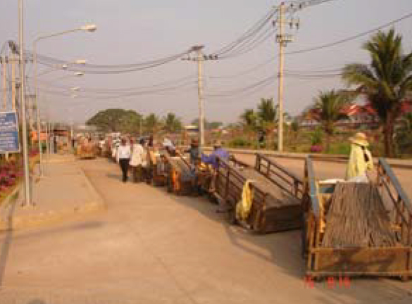 （写真③）早朝、カラの荷車を曳きタイ側に入るカンボジア人が長蛇の列を作っていた。