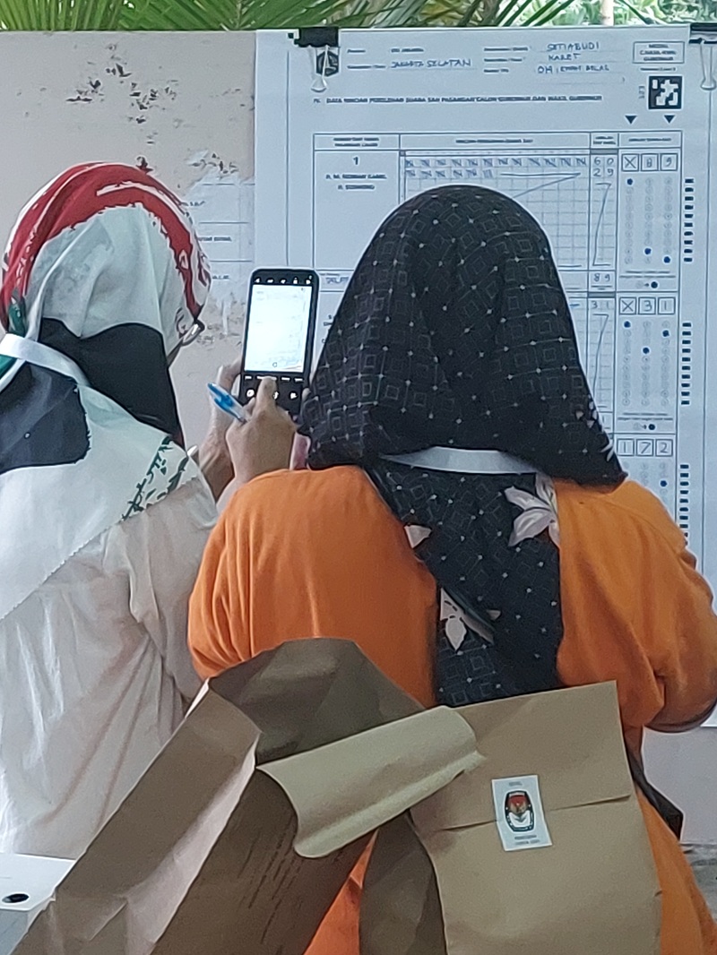 写真3　投票所係員が集計した模造紙をスマートフォンのカメラで撮っている様子