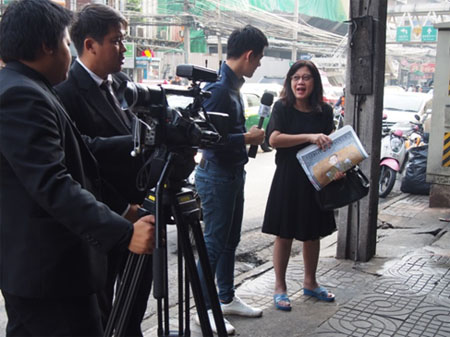 写真：新聞購入者に街頭インタビュー（10月18日）