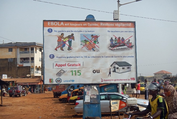 写真　啓発活動のための看板「エボラは常にギニアにある！気をつけよう！」病人を家に置いておかないこと、遺体にはふれないこと、フリーダイヤルへの連絡や近隣の医療機関での受診が推奨されている（2015年1月コンデ氏撮影）。