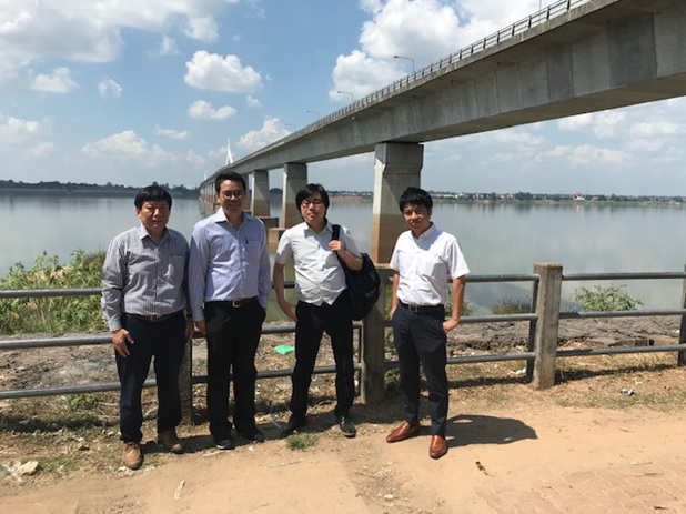 写真：橋の前にてプロジェクト・メンバー全員（日本人2名、タイ人1名、ラオス人1名）で記念撮影