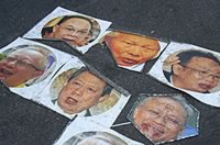 写真：UDD集会場の路上に貼られた顔写真。中央上がプレーム枢密院議長。