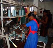 バングラデシュのニットウェア工場で編み機を操る女性労働者