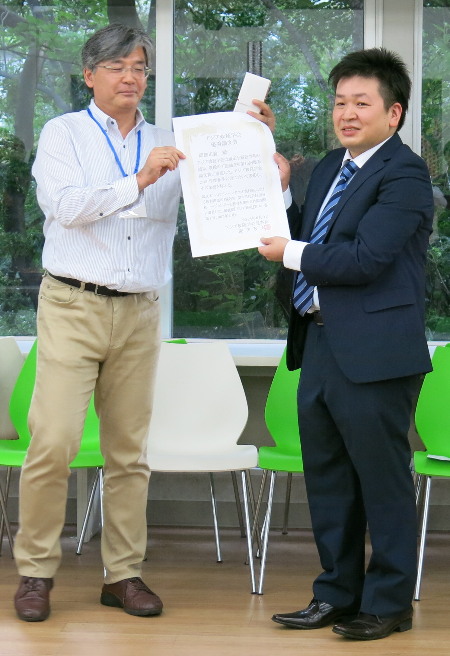 写真：園田茂人 アジア政経学会理事長（左）と、受賞した岡部正義海外研究員（右）